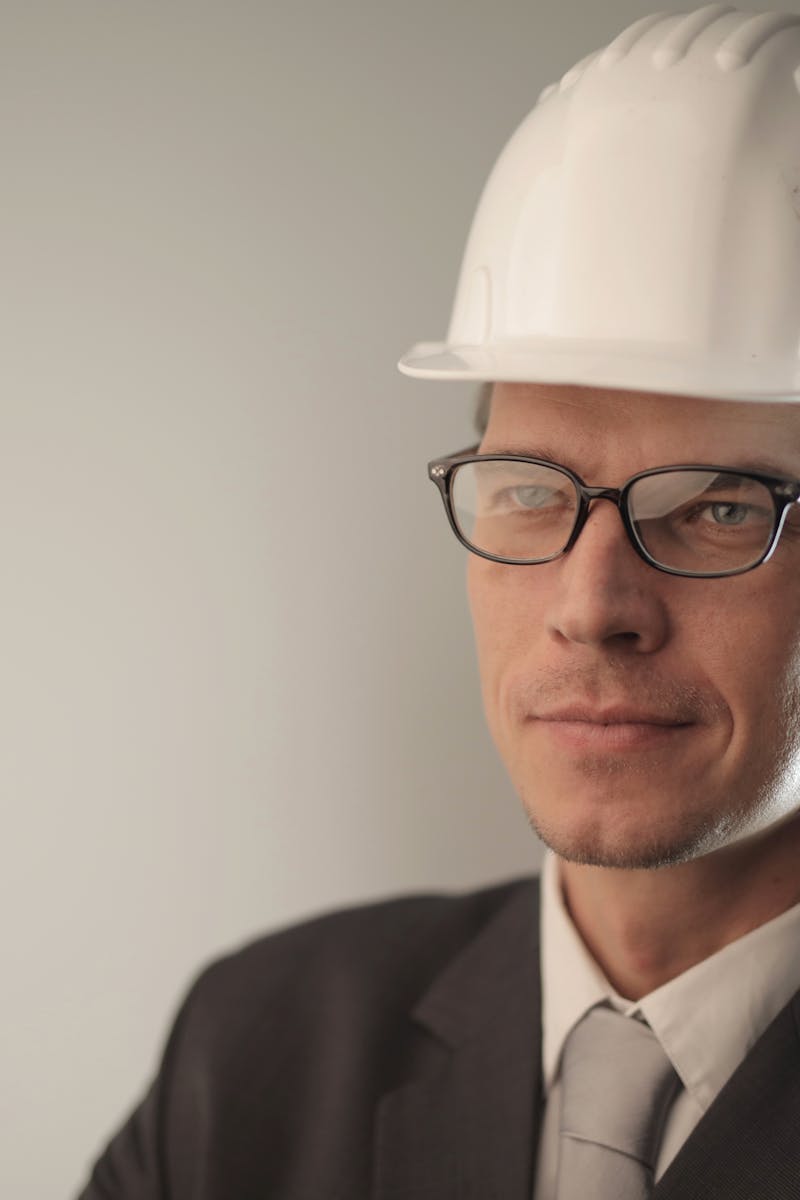 Confident engineer in suit and hard hat, ready for construction project.